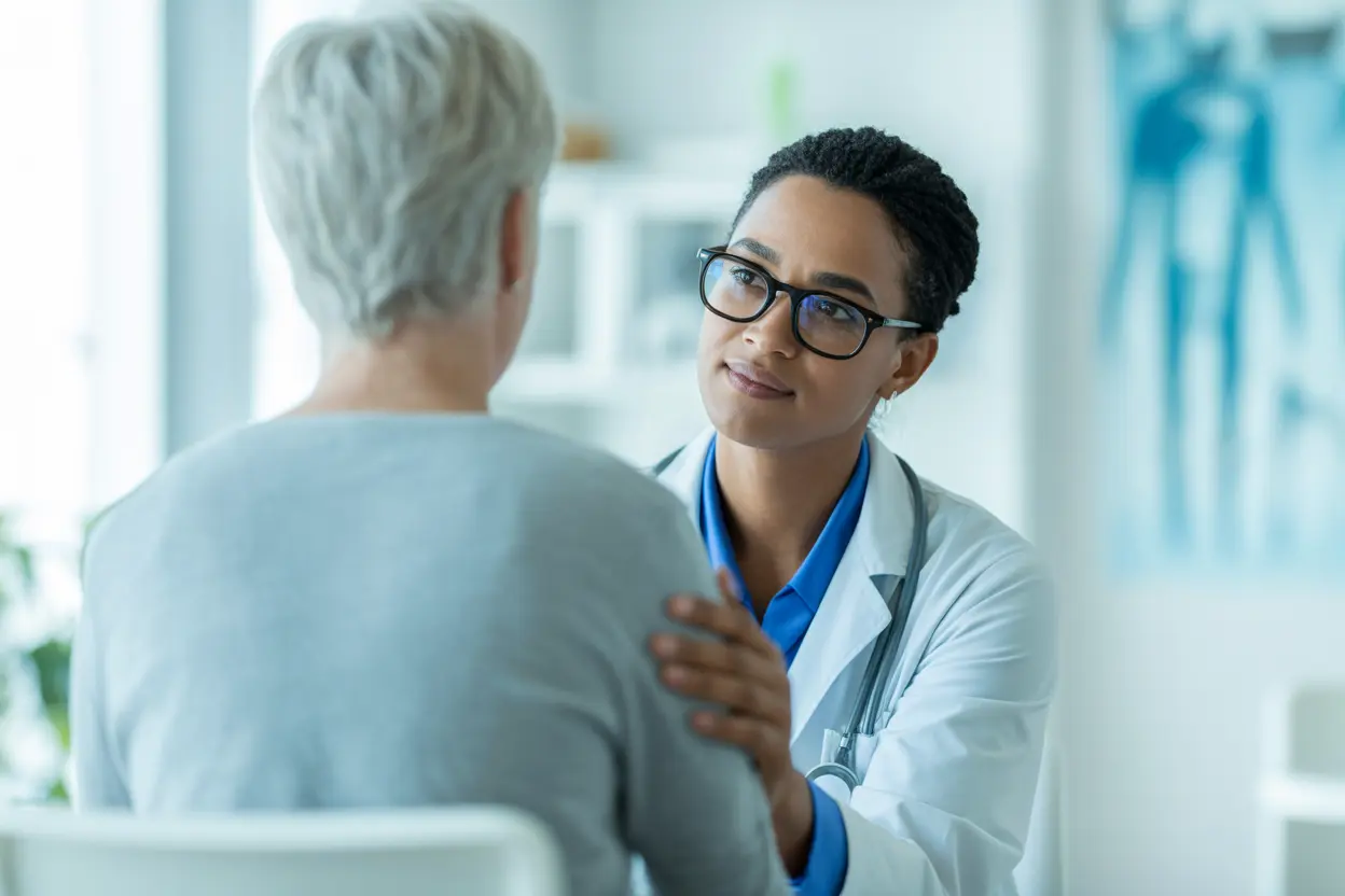 A medical professional compassionately listens to a patient in a bright, safe facility.
