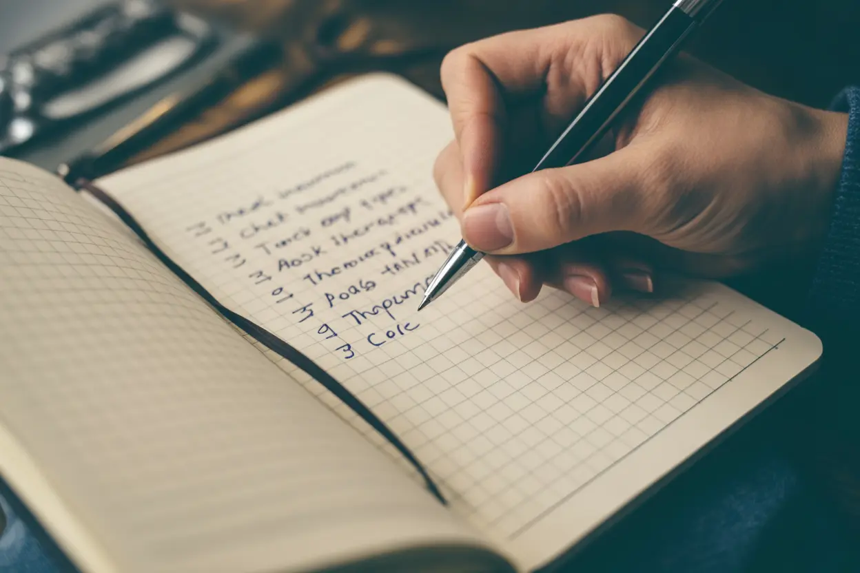 A person making a checklist in a notebook to help them choose the right eating disorder treatment program.
