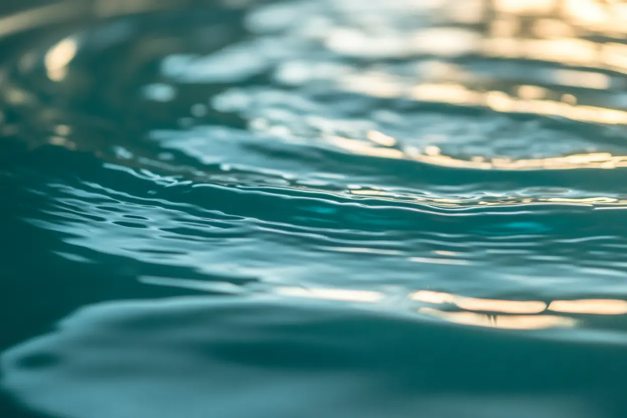 Calm water surface inside a float tank, representing sensory deprivation therapy.